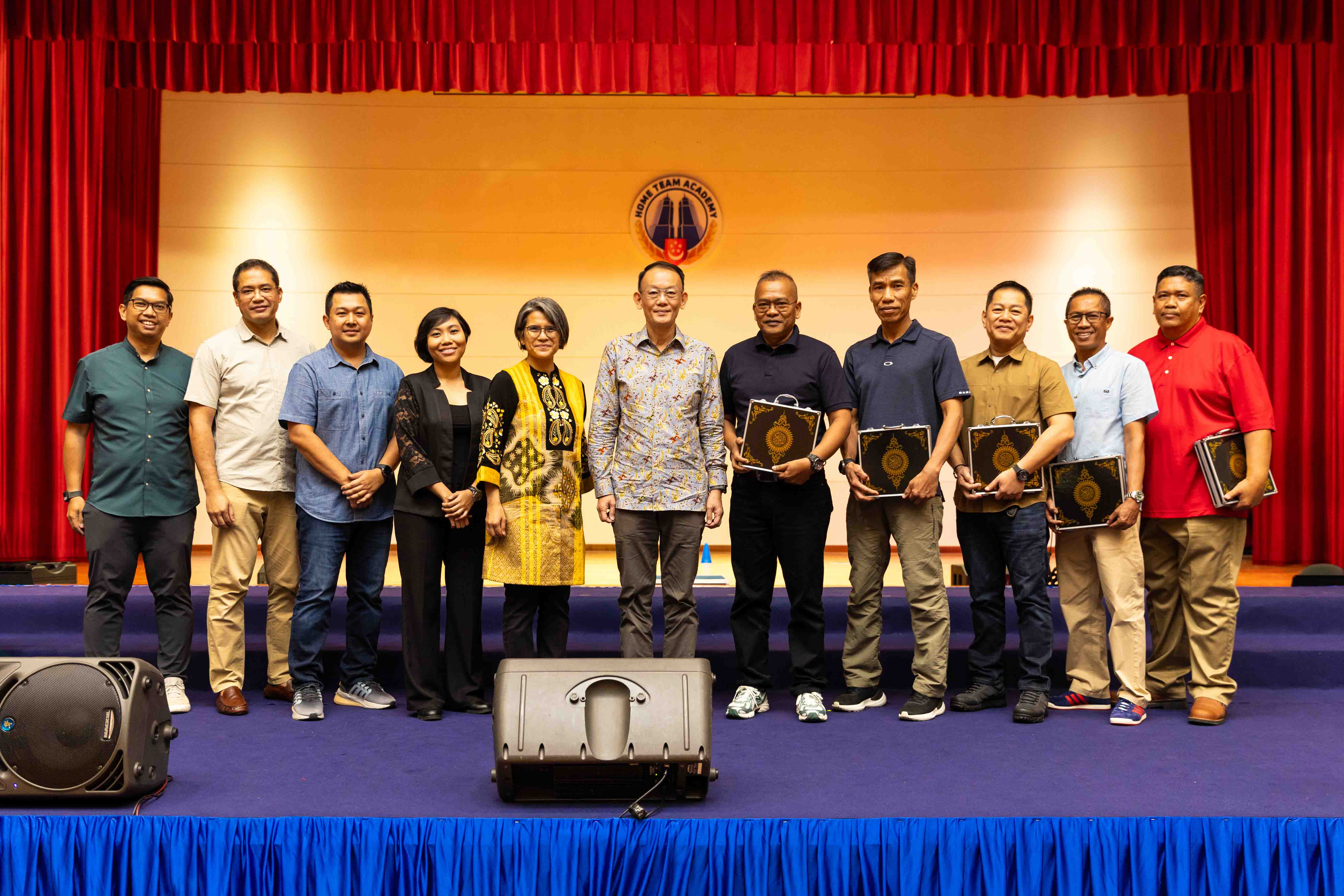 Management committee and Commissioner of Police stand on stage with recipients during appreciation and presentation segment.